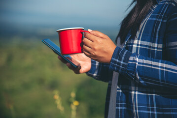 Close up women hands holding coffee cup smartphone E-commerce online Shopping website Reading...