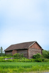 Rustic Wooden Barn Amidst Lush Greenery Under a Cloudy Sky