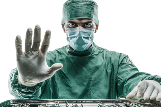 Surgeon in scrubs raises hand in stop gesture.