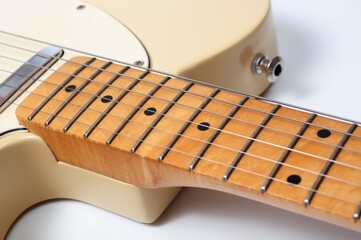 Six-string electric guitar, with a cream-colored wooden body and chrome-plated fittings.