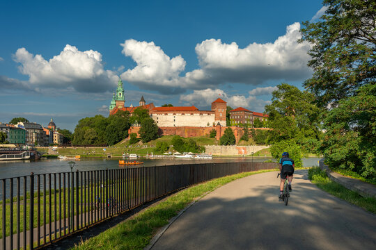 Krak&oacute;w: Rowerzysta jadący nad Wisłą z Wawelem w tle