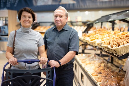 couple chooses sweet puffs in bakery