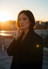 Golden Hour Portrait: A contemplative young woman stands bathed in the soft, warm light of the setting sun, her gaze direct and compelling, evoking a sense of serenity and introspection.