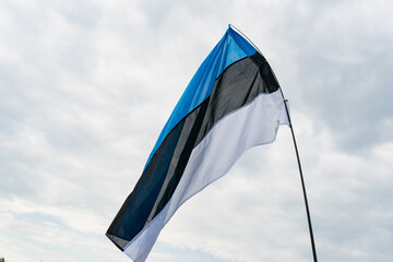 Estonian national flag waving in the wind against cloudy sky symbol of independence patriotism and...