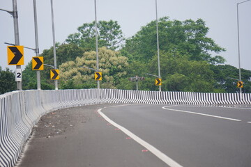 The curved section of a road on the flyover with several right curved signboards