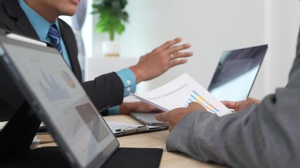 Business professional analyzing data in graph document and sharing insights during meeting with partners. Manager identifying trends, business challenges. - Powered by Adobe