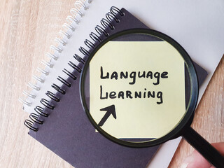LANGUAGE LEARNING, text note note taking on a sheet of paper through a magnifying glass. Language...