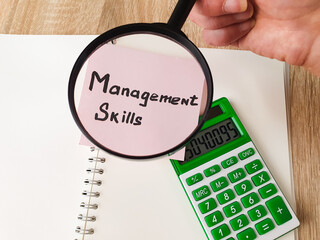 Management Skills text, word note on paper through a magnifying glass. Management skills business...