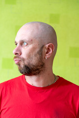A man poses against a wall, making various grimaces