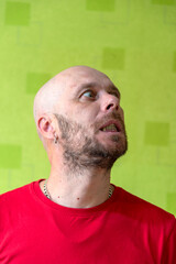 A man poses against a wall, making various grimaces