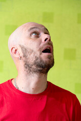 A man poses against a wall, making various grimaces