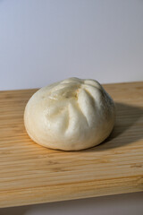 A Freshly Made Steamed Bun on a Wooden Cutting Board