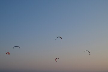 A lone kite in the sky during sunset above the sea and mountains in Turkey. Minimalist composition with soft colors and a sense of freedom, movement, and summer.
