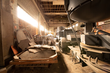 Abandoned Military Equipment and Searchlights in a Sunlit Industrial Warehouse with Dust and Decay