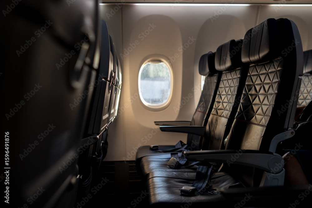 Poster empty airplane seats with a view of clouds outside the window during a flight at sunset