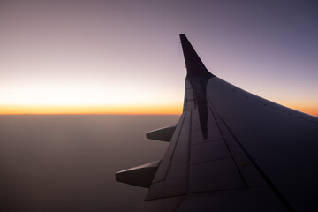 Sunset View From an Airplane Wing Over a Vast Sky During Twilight Hours