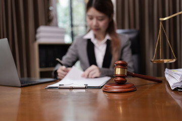 Female Lawyer Working on Document Paper with Writing Signature and Lawyer Hammer at Office Desk, Judge's Gavel, Law,
