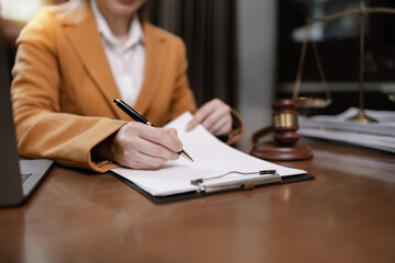 Female Lawyer Working on Document Paper with Writing Signature and Lawyer Hammer at Office Desk,...