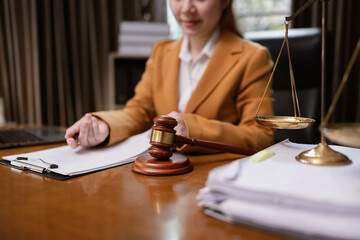 Female Lawyer Working on Document Paper with Writing Signature and Lawyer Hammer at Office Desk, Judge's Gavel, Law,
