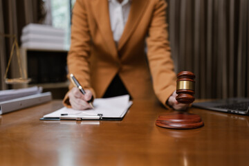Fototapeta premium Lawyer Holding Hammer with Document Paper on Wood table, Law, Justice Symbol,