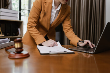 Female Lawyer Working on Document Paper with Laptop and lawyer Hammer at Office Desk, Judge's...