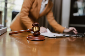 Female Lawyer Working on Document Paper with Laptop and lawyer Hammer at Office Desk, Judge's Gavel, Law,