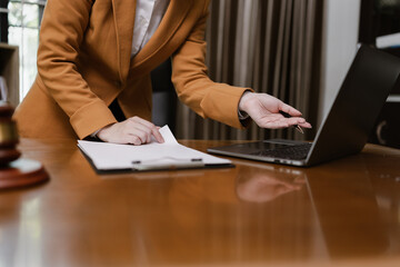 Female Lawyer Working on Document Paper with Laptop and lawyer Hammer at Office Desk, Judge's...