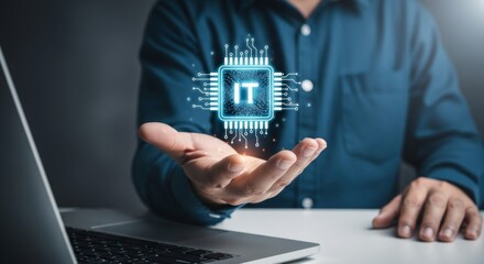 Person presenting a glowing blue IT chip hologram above their open hand, with a laptop in the foreground and a dark background.