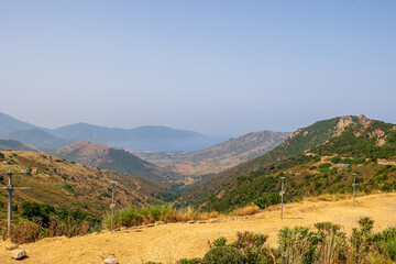 Naklejka premium Mountain view with haze and Mediterranean Sea on the horizon, France, Corsica, Apietto, 14 June 2025
