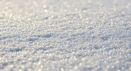 Obraz premium Glistening white snow crystals sparkle under sunlight creating a beautiful and shimmering winter background texture in a cool tone.