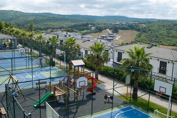 Outdoor Recreational Area Featuring Basketball Courts and Playground Equipment Near Residential...