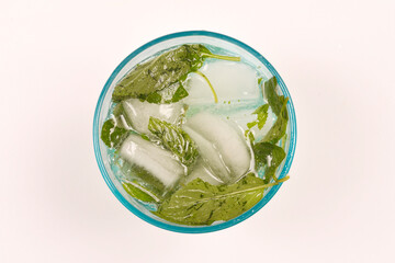 A refreshing drink with mint leaves and ice cubes in a glass, viewed from above