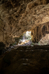 Exploring a Mysterious Cave With Natural Light Streaming Through During Daylight Hours