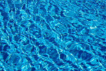 Bright Blue Water Reflecting Sunlight Creates a Serene Atmosphere in a Swimming Pool During a Sunny...