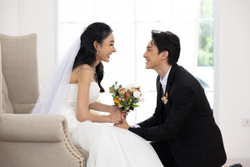 Asian Bride groom holding hands smiling happy love wedding bouquet veil dress suit indoor natural...