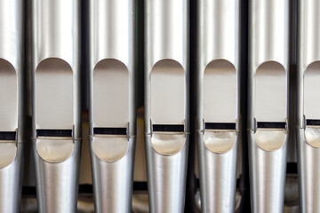 Old metal organ pipes, detail of a musical instrument in a church, part of a religious organ