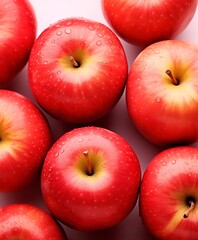 Red apples with water drops on pink surface