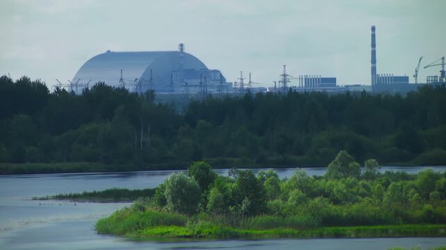 Chernobyl power plant view from Pripyat rive. Chernobyl new safe confinement arch from Pripyat rive. Ukraine