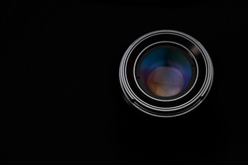 A close-up view of a camera lens on a black background.
