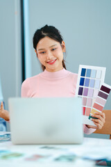 Designer reviewing office interior layout plan with paper drafts and material samples