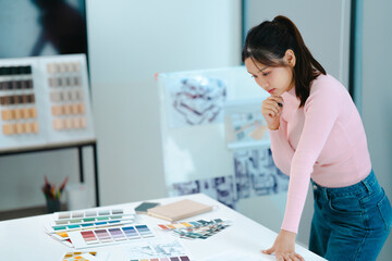 Designer reviewing office interior layout plan with paper drafts and material samples