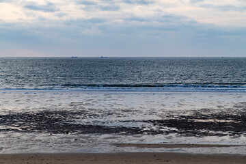 Fototapeta premium waves and clouds at the beach during sunset
