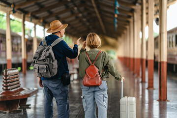 Mature couple waiting together at train station for journey
