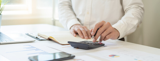Deduction planning, debt asian accountant hand using calculator to calculating money balance from...