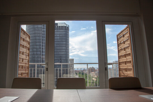 Oficina en piso alto con vistas a los edificios de Madrid desde grandes ventanales