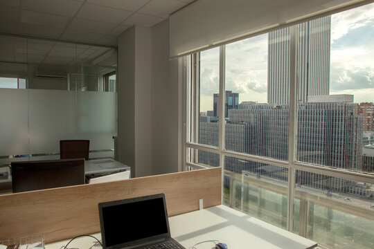 Oficina en piso alto con vistas a los edificios de Madrid desde grandes ventanales