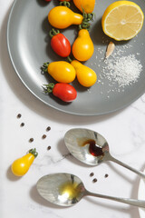 Summer salad ingredients - Freshly harvested cherry tomatoes, spoon of vinegar and olive oil, salt and pepper