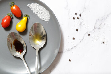 Summer salad ingredients - Freshly harvested cherry tomatoes, spoon of vinegar and olive oil, salt...