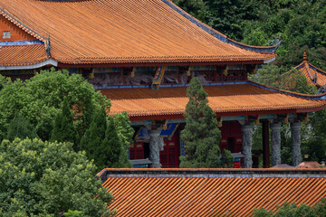 Ancient Temple with Red Tiles Surrounded by Lush Green Trees