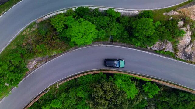 Drone view of serpentine asphalt road in mountainous area in Italian Alps. cars are going on a trip. Green planet. Tourism. Transport. Dangerous road. Italy Bergamo 24.08.2025
